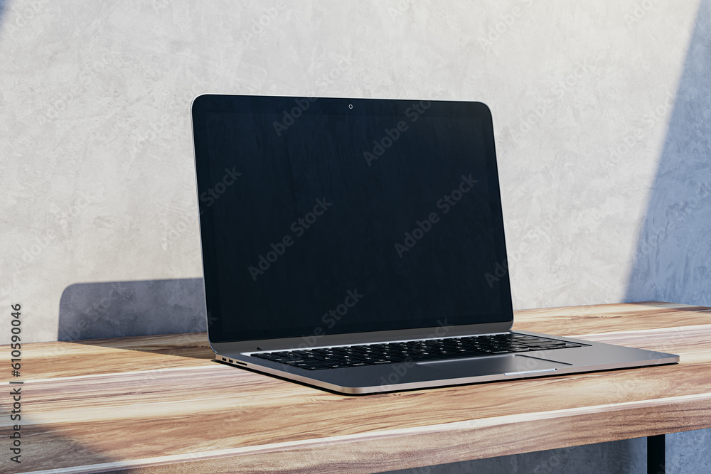 Poster Close up of empty mock up laptop computer screen on wooden desktop and concrete wall background with shadow. Designer desktop and ad concept. 3D Rendering.