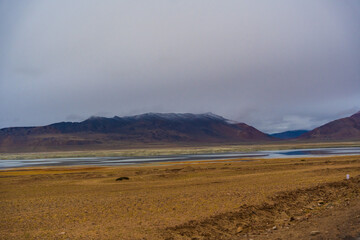 withered grass field, the mountain and cloud sky at Tso Kar lake, Beautiful scenery along the way at Ladakh, India. The Tso Kar or Tsho kar is a fluctuating salt lake