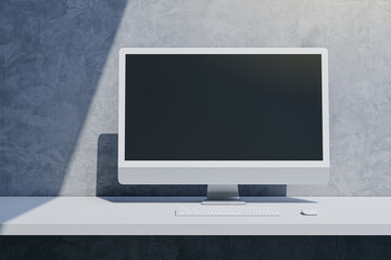 Close up of empty mock up computer display on desktop and concrete wall background with shadow. Designer desktop and ad concept. 3D Rendering.