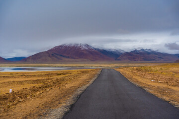 withered grass field, the mountain and cloud sky at Tso Kar lake, Beautiful scenery along the way at Ladakh, India. The Tso Kar or Tsho kar is a fluctuating salt lake