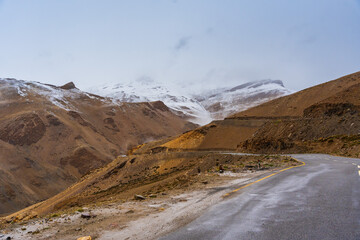 The road, Snow covered mountains, cloudy sky at Taglang La Pass, Keylong-Leh Road, the way from Moriri lake to Manali town, Ladakh, India