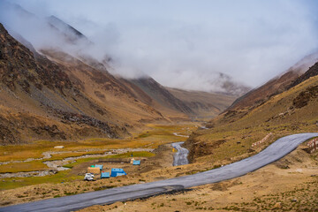 The road, Snow covered mountains, cloudy sky at Taglang La Pass, Keylong-Leh Road, the way from...