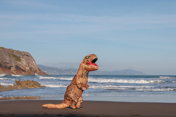 T-rex on the ocean beach in Zumaia, Spain. Dinosaur next to sea.. - 610592288