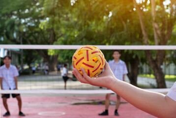 Sepaktakraw ball holding in hand of student who playing together afterschool, soft and selective...