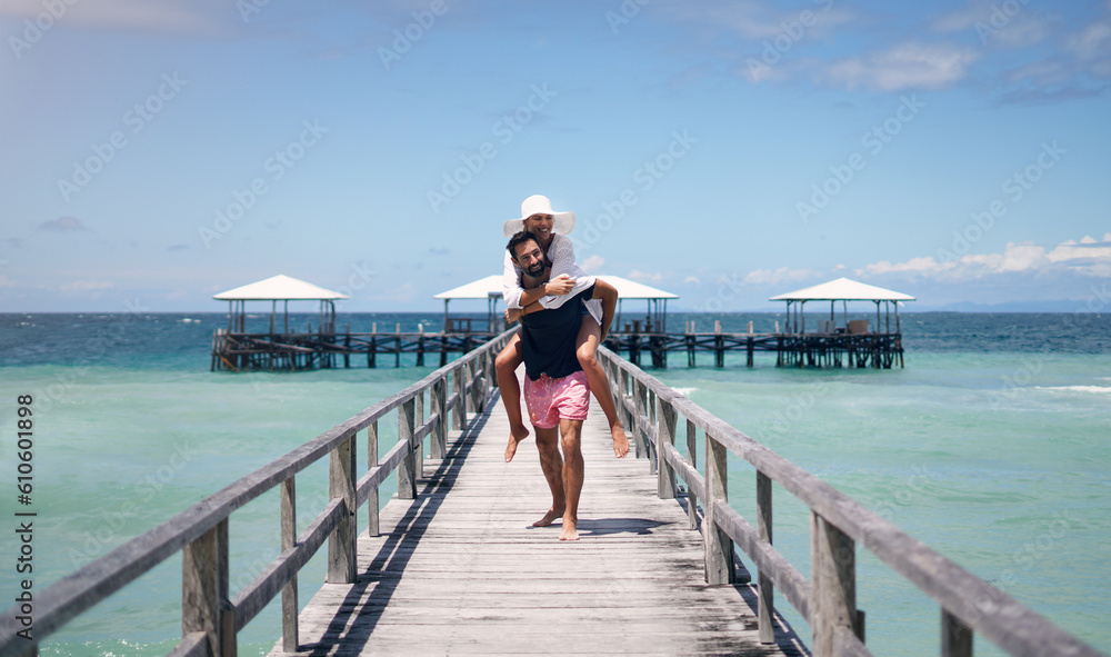 Canvas Prints Couple, piggyback and outdoor beach deck on a tropical island with love and water on holiday. Summer vacation, travel smile and Maldives playful in nature with freedom and happiness by ocean and sea