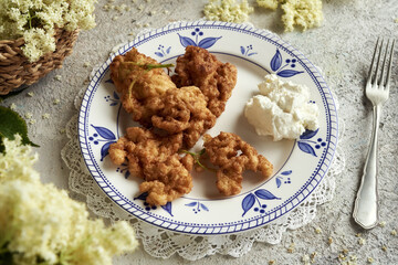Fried black elder flowers on a white and blue plate