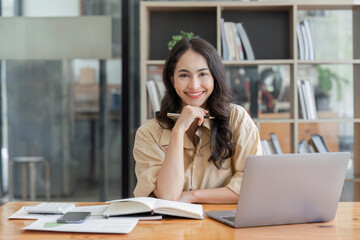 Business woman, portrait and smile at desk in office for paperwork, laptop. Happy, young or confident female worker with pride planning project at table in startup company