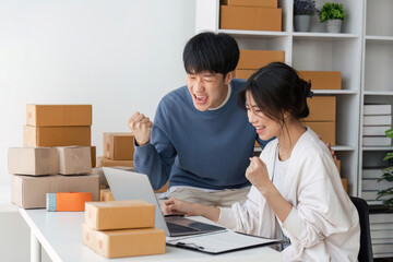 Image of Asian Happy couple people working in home. They are happy and success with their online store. Concept of freelancer startup and online business
