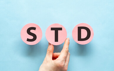 Hand holding pink cards with the word STD, Medical Concept.