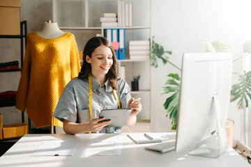 Young business owner woman prepare parcel box and standing check online orders for deliver to...