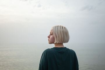 Pretty young adult woman with short blonde hair outdoor portrait