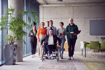 A diverse group of businessmen, including a businessman in wheelchair, confidently stride together through a modern, spacious office, epitomizing collaboration, inclusivity, and strength in unity