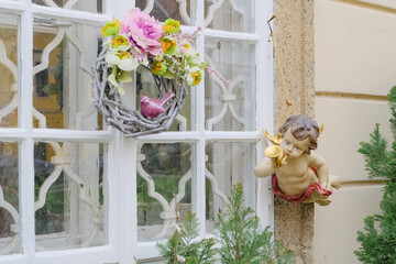 window with flowers wreath and angel statue outdoor decor, easter or wedding traditions