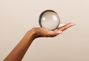 Crop black woman with transparent glass ball