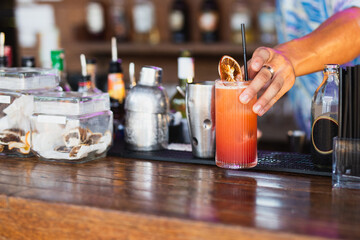 Fototapeta na wymiar Bartender serves a ready made alcoholic cocktail at the bar.
