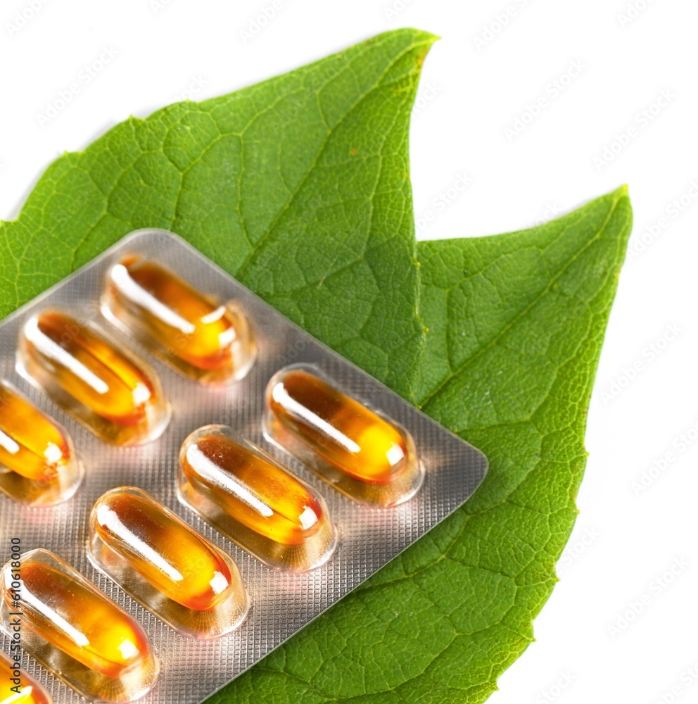 Poster herbal colored medical capsules on green leaf