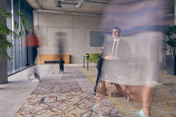 A businessman in a wheelchair in a modern office, surrounded by his colleagues who are portrayed with blurred movements, symbolizing their support and solidarity as they navigate the workspace