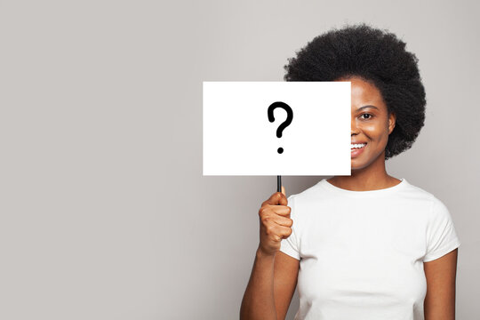 Attractive woman hiding her face with papper banner board with question mark on white background