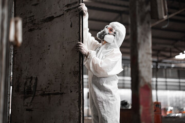 Industrial waste inspector wearing personal protective equipment to check hazardous chemicals,...