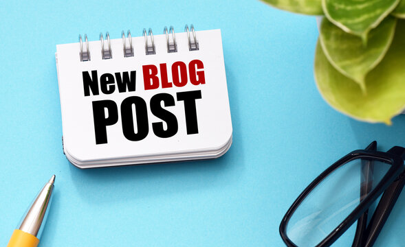 NEW BLOG POST words in notebook on blue background.