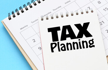 TAX PLANNING words in a notebook on a calendar.