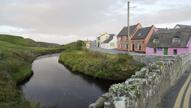 Aille River flows peacefully next to Colorf Houses in Doolin River