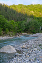 river Enza in the Apennines mountains in Parma, Emilia Romagna, Italy across mountains and forest in sunset lights. Travel, nature, trekking

