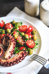 salad with octopus, tomatoes, olives and arugula. fresh healthy salad