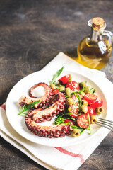 salad with octopus, tomatoes, olives and arugula. fresh healthy salad