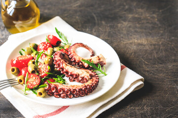 salad with octopus, tomatoes, olives and arugula. fresh healthy salad