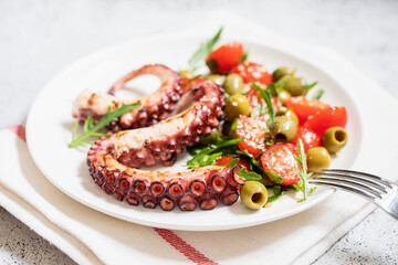salad with octopus, tomatoes, olives and arugula. fresh healthy salad
