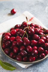 Composition of sweet cherries on a plate with water drops. Summer and harvest concept. Cherry macro. Vegan, vegetarian, raw food
