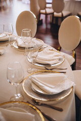 Wedding. Decor. Banquet. On the festive table there are plates and glasses, laid napkins and cutlery