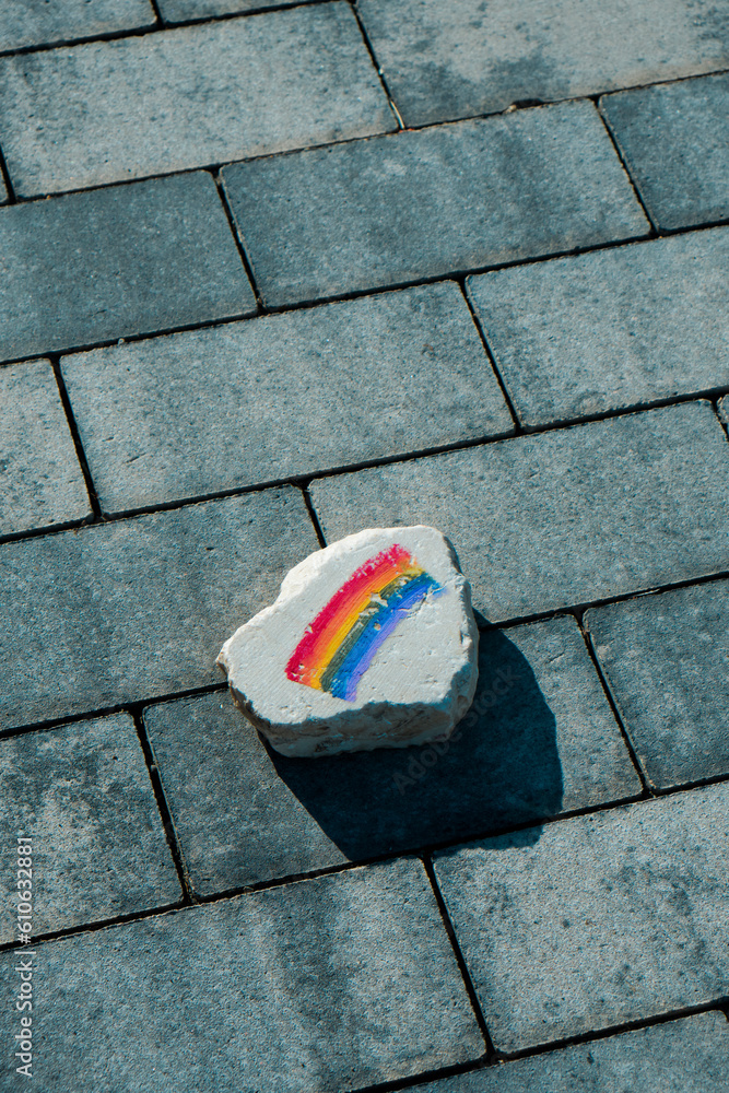 Sticker rock with a rainbow flag on the street