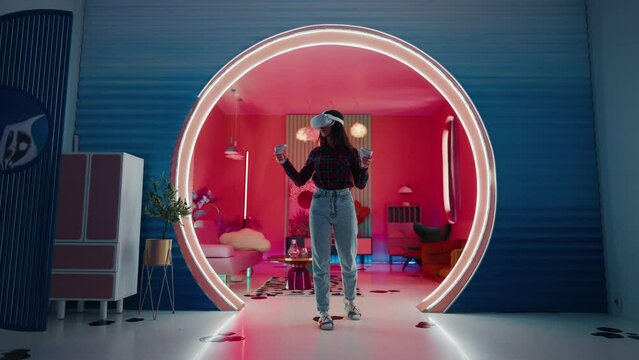 Woman actively uses VR glasses and two controllers to win fantasy adventure