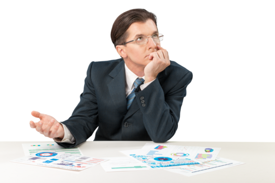 Young businessman sitting at desk and looking in chart