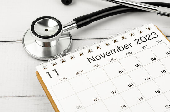 The stethoscope medical and November 2023 calendar wooden background, schedule to check up healthy concepts.