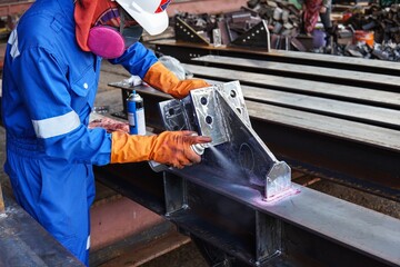A technician is inspecting a weld with non-destructive penetrant testing for defects in the weld.