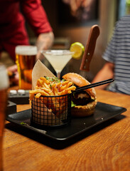 Close-up of young caucasian friends in casual clothing enjoying fast food and drinks at restaurant