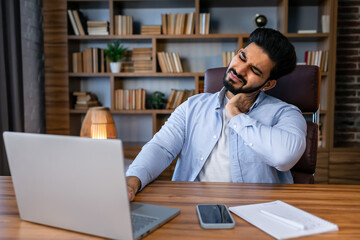 Feeling exhausted. Frustrated young handsome man looking exhausted while sitting at his working place .