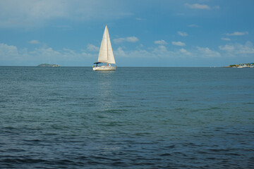 Obraz premium White yacht boat sail on turquoise water blue sky with cloud