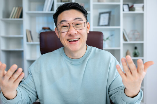 Happy millennial business man in casual making video call from home couch, looking at camera, smiling, attending online chat, virtual conference. Video call head shot portrait