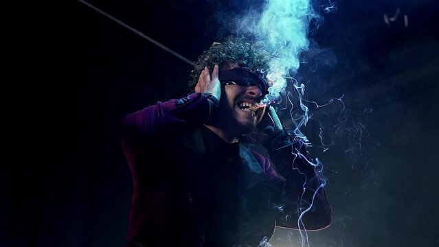 Man performing a magic show holding a lit firecracker with his mouth. Slow motion close-up 