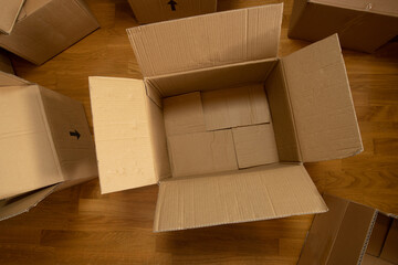 An empty cardboard box on the floor. Packing for moving. Box for logistics.