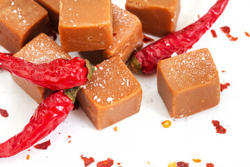 caramel fudge with chili flakes and coarse salt, sweet, spice, salty on white
