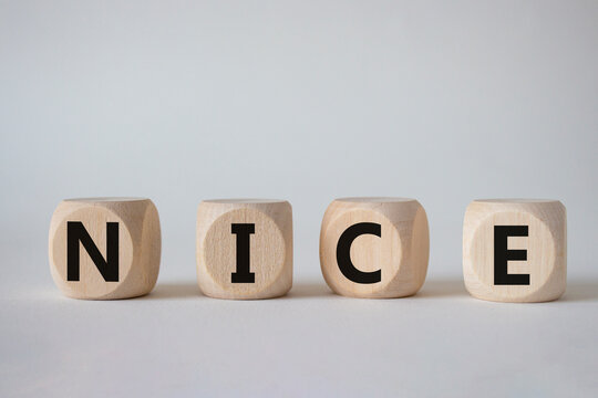 Nice symbol. Concept word Nice on wooden cubes. Beautiful white background. Business and Nice concept. Copy space.