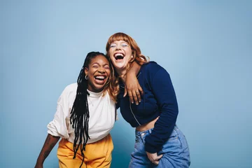 Fotobehang Two interracial best friends laughing and having a good time together in a studio © Jacob Lund