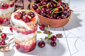  Overnight cherry oatmeal in jar. Sweet and sour breakfast oat porridge, with oats flakes.  vanilla yogurt and cherries