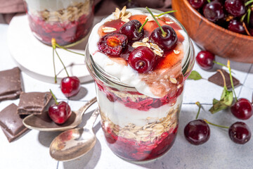  Overnight cherry oatmeal in jar. Sweet and sour breakfast oat porridge, with oats flakes.  vanilla yogurt and cherries