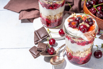  Overnight cherry oatmeal in jar. Sweet and sour breakfast oat porridge, with oats flakes.  vanilla yogurt and cherries